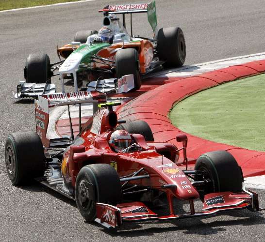 Kimi Raikkonen, da Ferrari, contorna curva à frente de Adrian Sutil, da Force India