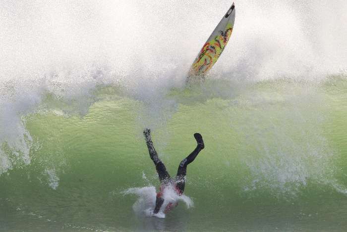 O surfista Royden Bryson cai da prancha após tentativa durante prova na Cidade do Cabo (AFS)