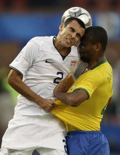 Jonathan Bornstein, dos EUA, sobe com Maicon, do Brasil, em disputa de bola