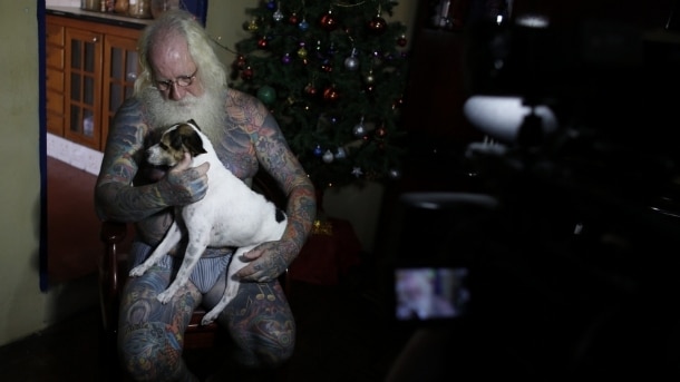 Vitor Papai Noel rock an roll com seu mascote biggle no colo.