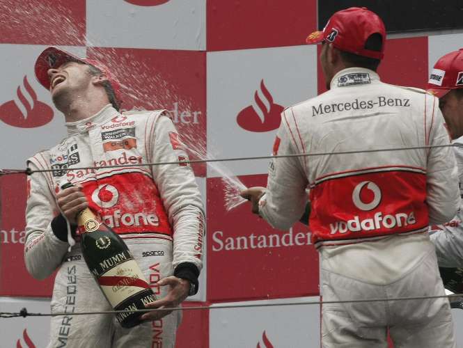 Jenson Button toma banho de champanhe do companheiro de McLaren Lewis Hamilton, no pódio na China