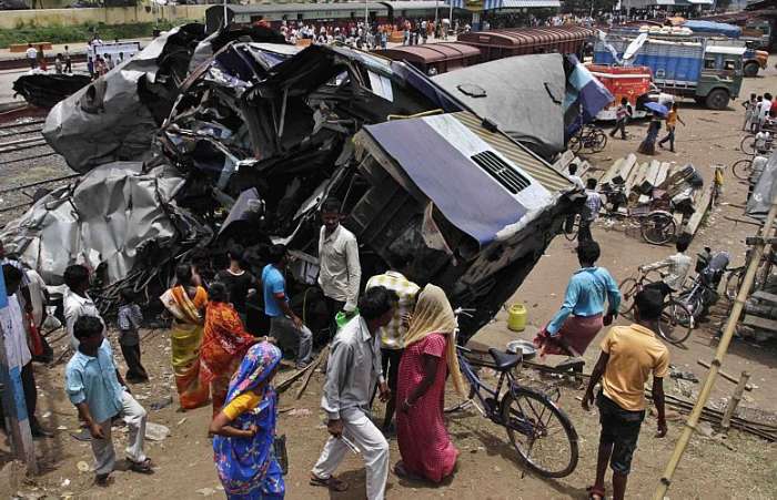 Indianos observam trem que descarrilou ontem, na Estação Sainthia, deixando 61 mortos e ferindo 165