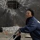 Sul-coreana caminha pelo local danificado com o ataque da Coreia do Norte