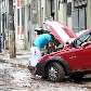 Motorista avalia os danos em um carro na Avenida Presidente Wilson, após a forte chuva 