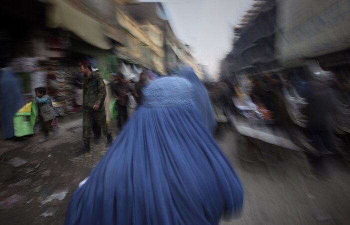 Dia-a-dia afegão: mulher caminha por mercado em Cabul