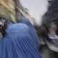 Dia-a-dia afegão: mulher caminha por mercado em Cabul