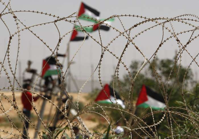 Palestinhos mostram bandeiras durante demonstração contra o muro construído em Gaza