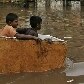 Crianças brincam de atravessar rua submergida após fortes chuvas no Sri Lanka