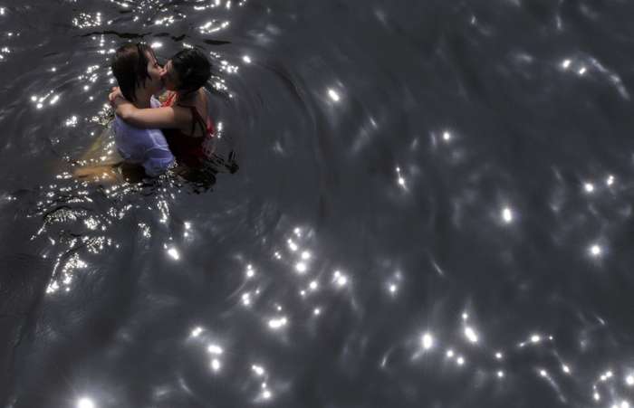 Altas temperaturas chegam na capital ucraniana, Kiev; pessoas se refrescam no Rio Dnieper