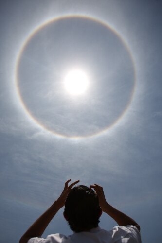 Ao refletir os raios de sol na água, pode ser visto um arco-íris em volta do sol