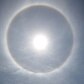 Ao refletir os raios de sol na água, pode ser visto um arco-íris em volta do sol Ao refletir os raios de sol na água, pode ser visto um arco-íris em volta do sol