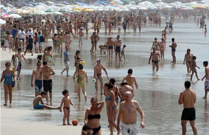 Banhistas na praia das Astúrias no Guarujá, litoral sul de São Paulo