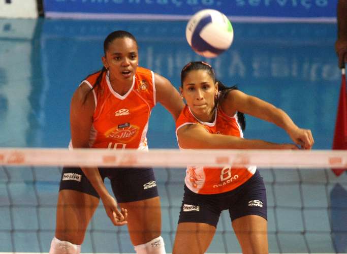 A levantadora Sassá observa a ponteira Jaqueline, ambas de Osasco, devolver a bola, na Superliga