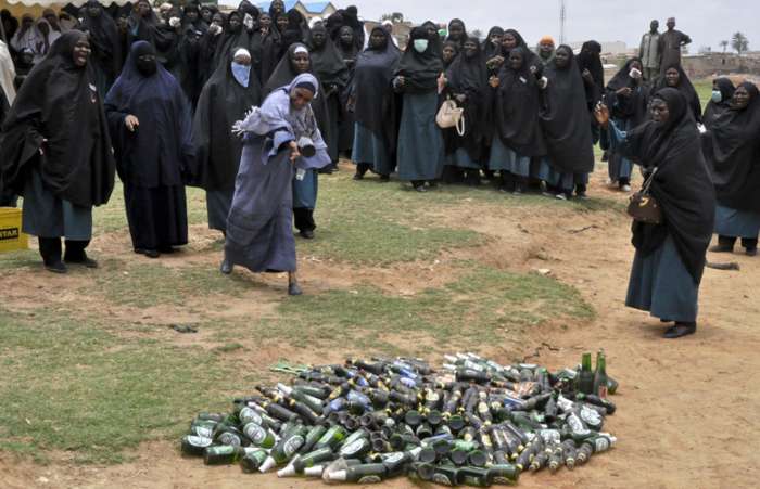 Policia feminina islâmica destrói garrafas de cerveja pela abolição de consumo de álcool, Nigéria
