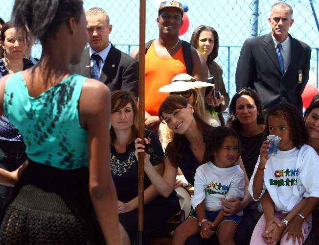 Acompanhada da viúva do jornalista Roberto Marinho, Dona Lily, Bruni assistiu a um desfile de modas.