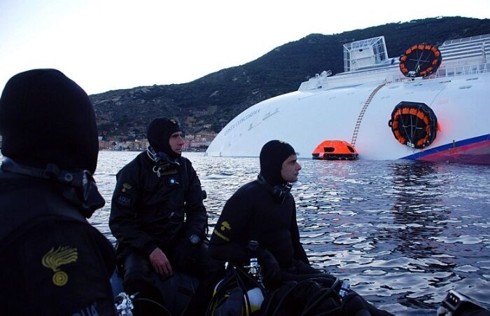 Mergulhadores buscam corpos de desaparecidos em meio ao navio parcialmente submerso