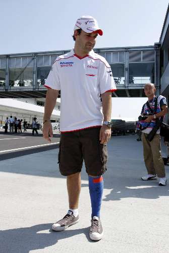 Timo Glock exibe a perna machucada após acidente no treino do GP do Japão