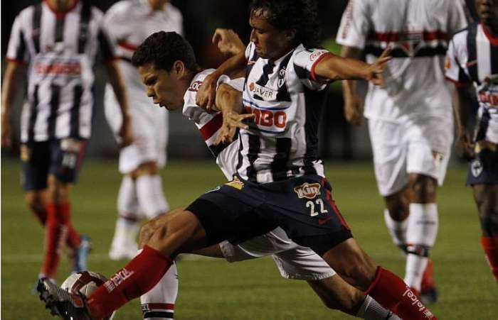 Hernanes e Paredes brigam pela bola no empate entre São Paulo e Monterrey