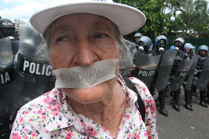 Manifestante protesta contra fechamento de rádio e televisão por parte do governo hondurenho