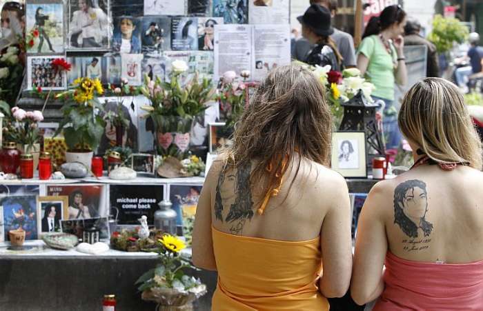 Fãs, que tatuaram o rosto de Michael Jackson, respeitam um minuto de silêncio, na Alemanha