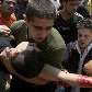 Palestinos ajudam jovem ferido durante enfrentamento com soldados israelitas em Gaza