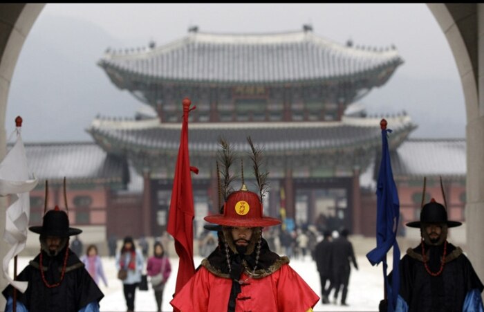 Sul coreanos, vestidos com tradicionais roupas militares, ficam de guarda no Palácio Gyeongbok, Seul