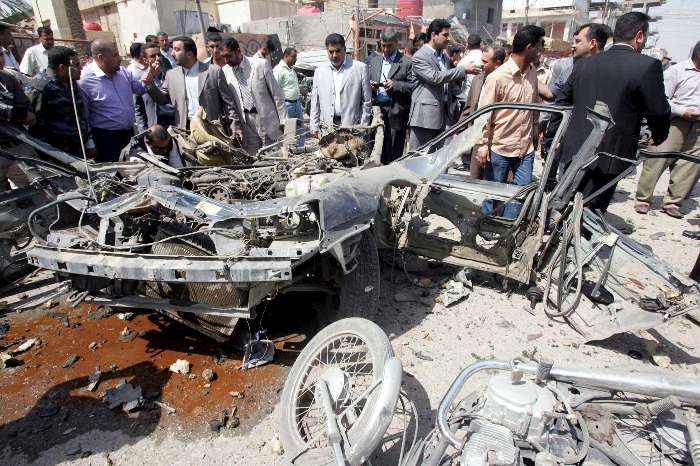 Homens inspecionam lugar onde houve um carro bomba em Kerbala, ao sul do Iraque