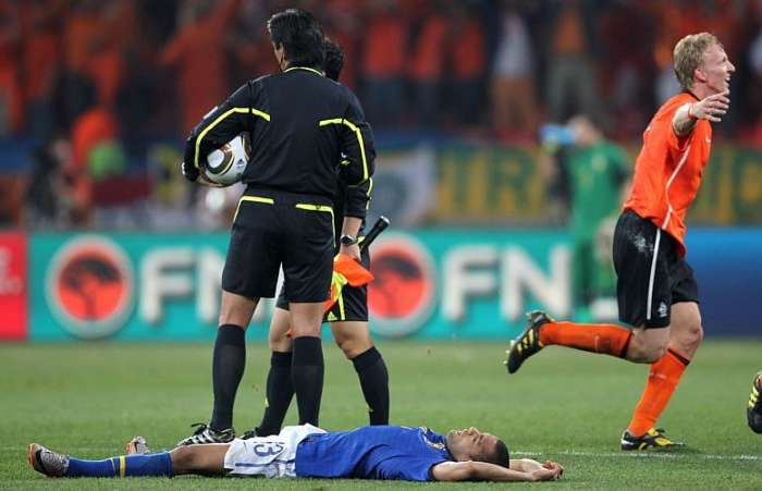 Daniel Alves estendido no gramado após o fim do jogo que tirou o Brasil da copa 2010