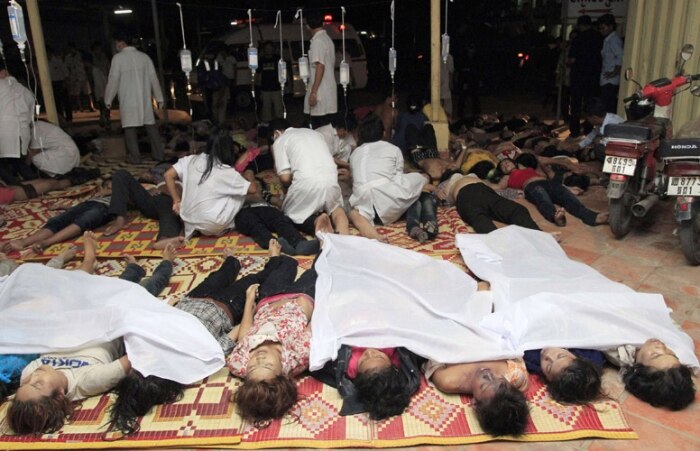 Policiais levam os mortos para o hospital em Phnom Penh; 180 pessoas morreram
