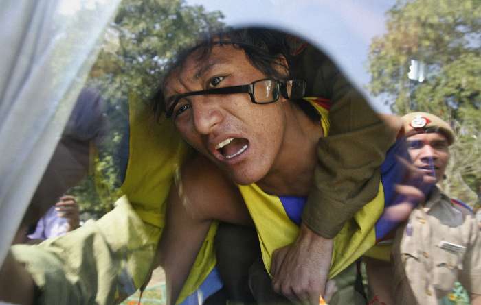 Tibetano exilado grita de dentro de uma van policial por protestar em frente a embaixada chinesa