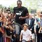Jamaicano Usain Bolt brinca de correr com uma criança na Grécia