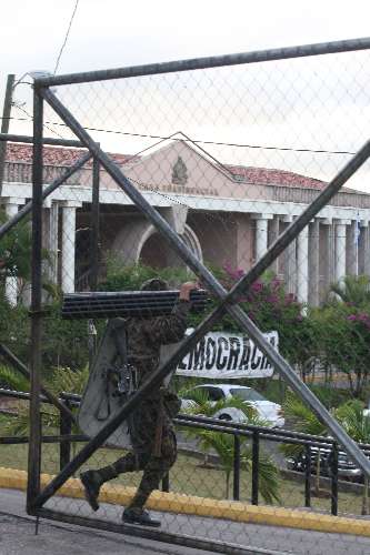 Soldado se prapara para se instalar em frente à residência presidencial em Tegucigalpa
