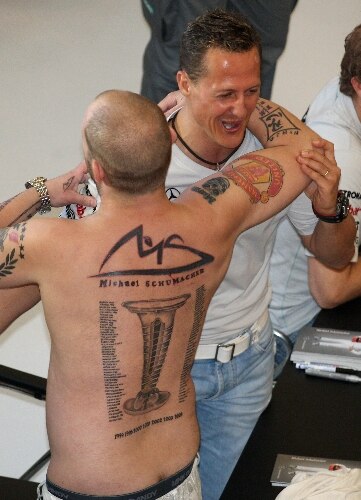 Schumacher abraça fã que tatuou nas costas todos os títulos do piloto e corridas vencidas na F1