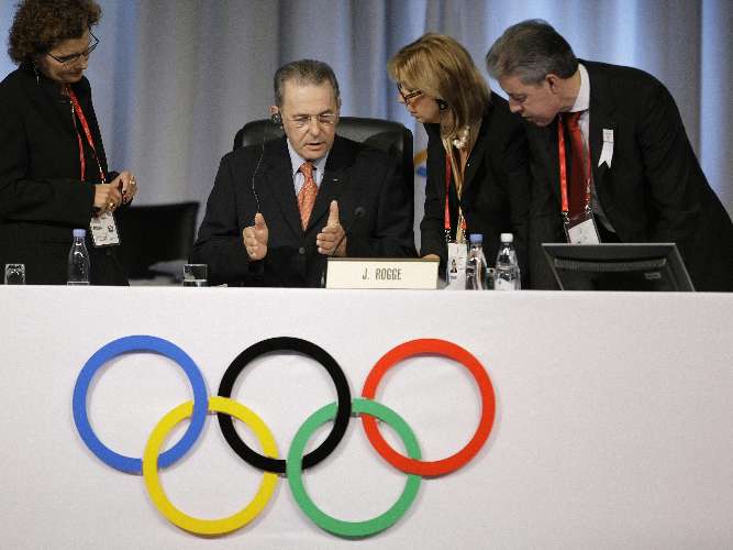 Jacques Rogge, presidente do COI, conversa com funcionários após apresentação