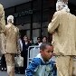 Artistas caminham pela Av Paulista com roupas sociais sujas com argila Artistas caminham pela Av Paulista com roupas sociais sujas com argila