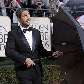 O ator Gerard Butler brinca com o guarda-chuva durante chegada ao tapete vermelho da premiação