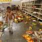 Criança caminha em supermercado saqueado em Tegucigalpa