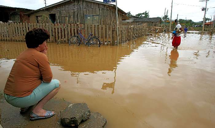 Moradora observa as ruas de Itajaí, tomada pelas águas