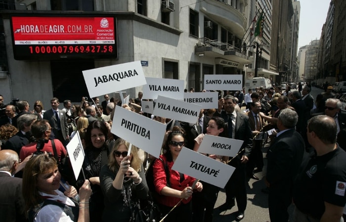 Funcionários de diversas filiais do Comércio de SP protestam com placa de sua região e apitos