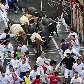 Da sacada das casas, pessoas assistem à corrida dos touros pelas ruas de Pamplona