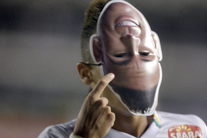Neymar comemora seu gol com uma máscara distribuída no estádio para os torcedores e é expulso