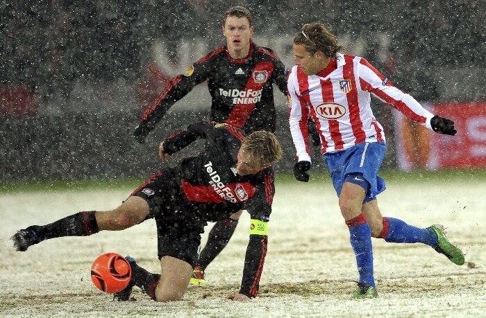 Sami Hyypia, do Bayer Leverkusen, chuta bola sob neve e antes de Diego Forlan, do Atlético de Madrid