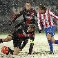 Sami Hyypia, do Bayer Leverkusen, chuta bola sob neve e antes de Diego Forlan, do Atlético de Madrid
