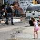 Menina observa corpo de um dos mortos durante confronto da PM com traficantes na Rocinha