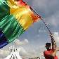 Manifestante flamula a bandeira da força homossexual em frente a Esplanada dos Ministérios Manifestante flamula a bandeira da força homossexual em frente a Esplanada dos Ministérios