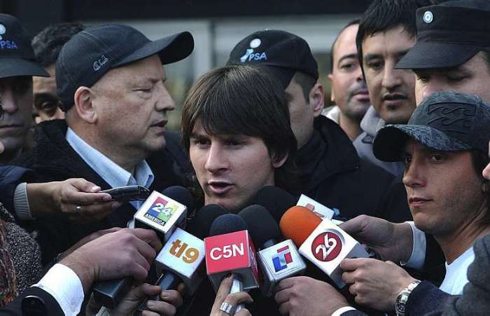 Lionel Messi é rodeado por repórteres no seu desembarque na Argentina