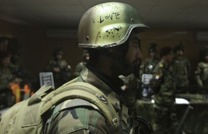 Soldado afegão usa um capacete cravado 