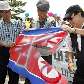 Bandeira da Coreia do Norte é rasgada em Seul; Pyongyang é acusada de iniciar o conflito com invasão Bandeira da Coreia do Norte é rasgada em Seul; Pyongyang é acusada de iniciar o conflito com invasão