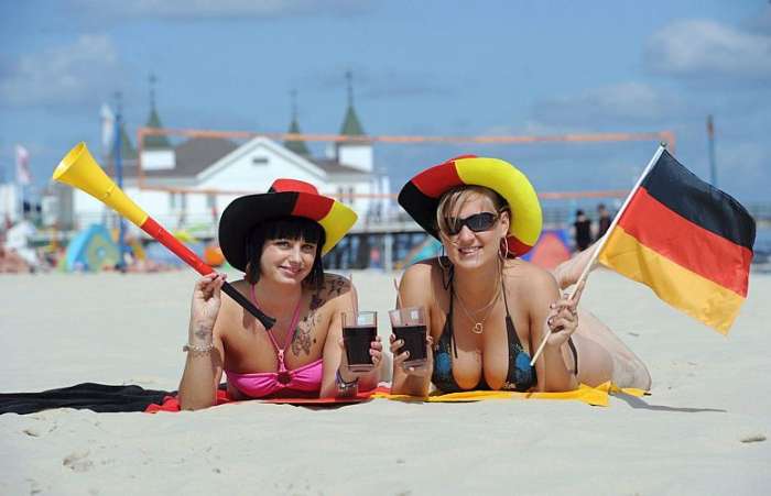 Na praia de Ahlbeck, na Alemanha, torcedoras posam para foto antes do jogo contra a Espanha 