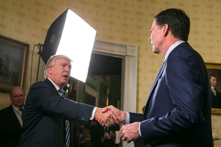 Trump cumprimenta o então diretor do FBI, James Comey, em recepção na Casa Branca em 22 de janeiro, dois dias após a posse do republicano